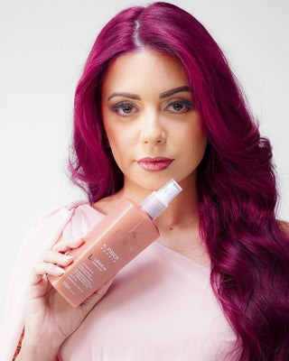 Kostume Rio de Janeiro USA - Woman with vibrant marsala hair holding a K. Fiber Acidificante 3.0 bottle against a light background